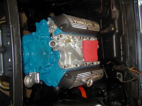 1970 Ford Mustang - Engine assembly with Cobra valve covers, likely a Ford V8, in a workshop setting.
