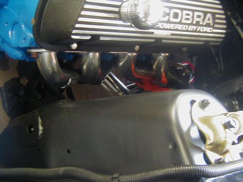 1970 Ford Mustang - Detail shot of a Ford Cobra engine valve cover and exhaust headers, indicating a performance engine.