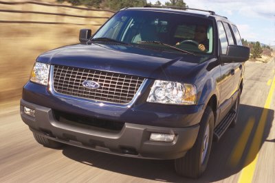 2003 Ford Expedition - The front grille and headlights of a 2003 Ford Expedition are visible as it drives down a highway.