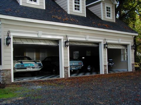 1970 Ford Mustang - A light blue 1969 Ford Mustang Mach 1 is parked in a three-car garage alongside two other vehicles.