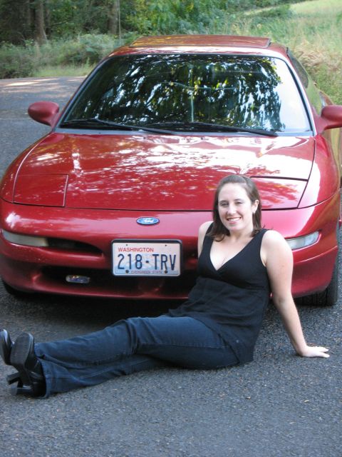 1997 Ford Probe - A red 1997 Ford Probe is shown from the front with a woman sitting on the ground before it.