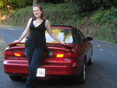 1997 Ford Probe - A woman poses with a red Ford Probe on a tree-lined road.