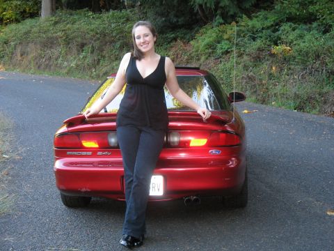 1997 Ford Probe - A woman poses with a red 1997 Ford Probe on a paved road.