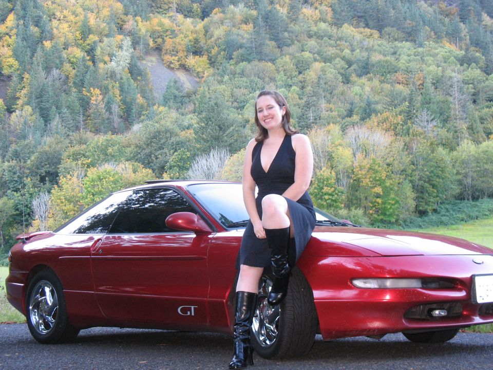 Red 1997 Ford Probe GT coupe with woman on hood