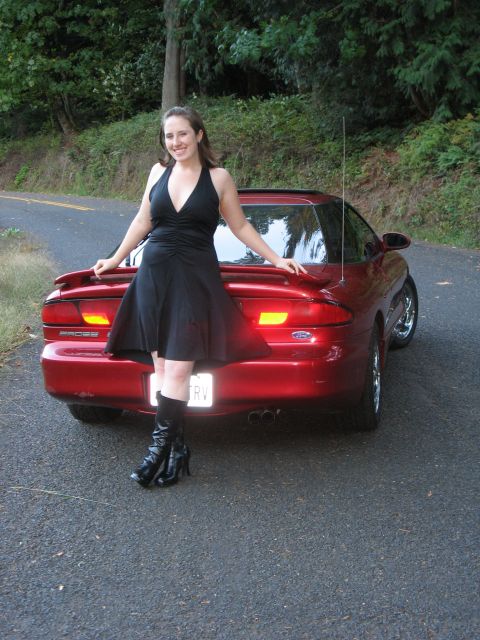 1997 Ford Probe - A woman poses with a red Ford Probe on a tree-lined road.