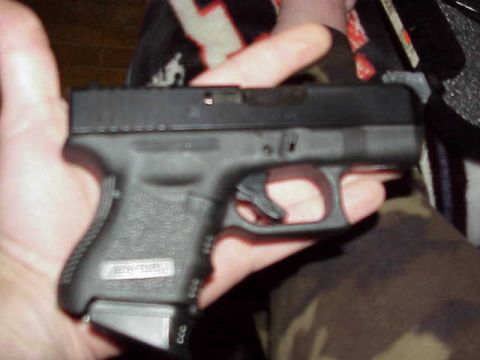 1993 Ford Bronco - A Glock pistol is held in a person's hand, showing the grip and magazine.