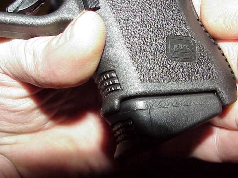 1993 Ford Bronco - A hand grips the textured handle of a Glock pistol, showing the brand's logo.