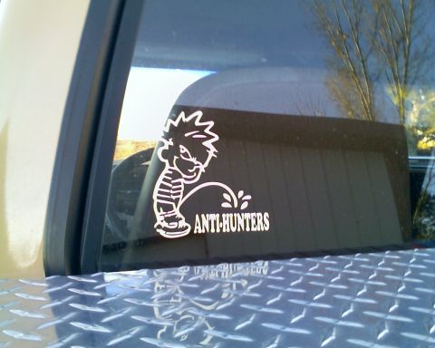 1979 Ford F-150 - Close-up of a pickup's rear cab window wearing a white 'ANTI-HUNTERS' peeing-boy vinyl decal, shot from just above the bed rail. A diamond-…