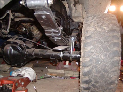 1991 Ford Bronco - Close-up view of the rear axle and suspension components of a vehicle, possibly undergoing maintenance.