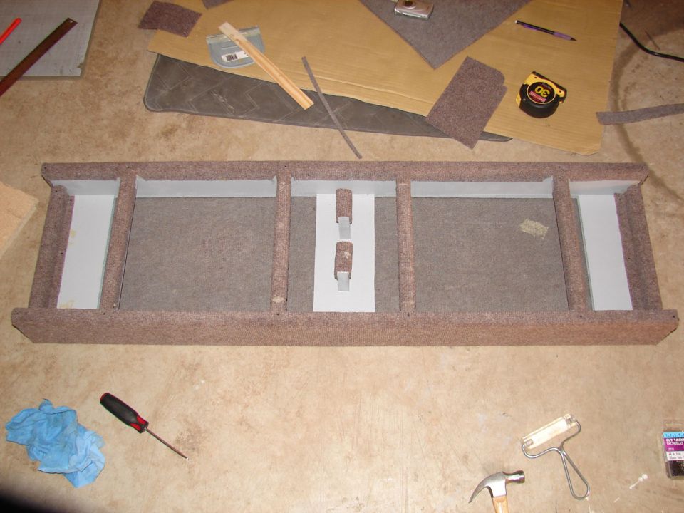 custom speaker enclosure with multiple compartments, tools and carpet scraps around it
