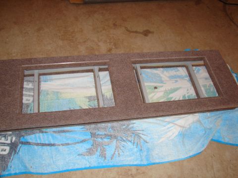 1996 Ford Bronco - A stereo mounting bracket with two openings is shown, placed on a towel with a tropical design.