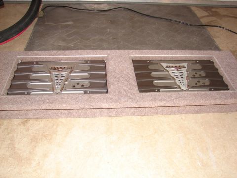 1996 Ford Bronco - Two Kicker car stereo amplifiers are mounted in a carpeted enclosure, likely for installation in a vehicle.