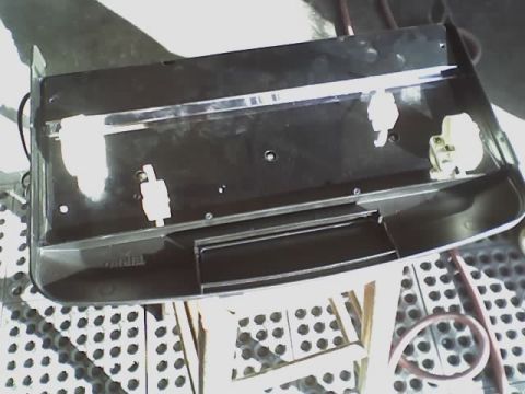 1993 Ford C-350 (Centurion Conversions) - A black plastic part with chrome trim and white clips is shown, with the word 'TEMPEL' visible on its surface.