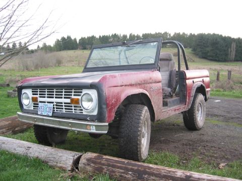 1968 Ford Bronco - This 1968 Ford Bronco is shown in a rural setting with a dirt road and grassy hills in the background.
