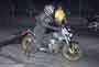 1965 Ford Mustang - A motorcycle and its rider are captured in a side profile at night, with the front of the vehicle angled towards the viewer.