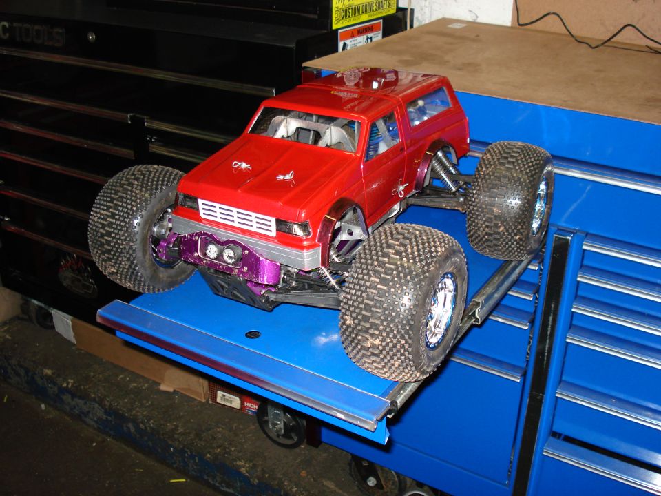 Red remote control truck with large tires and purple suspension components