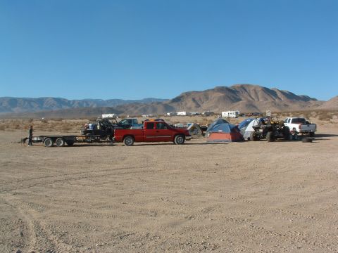1994 Jeep YJ - Camp setup in the desert with several vehicles and tents under a clear blue sky.