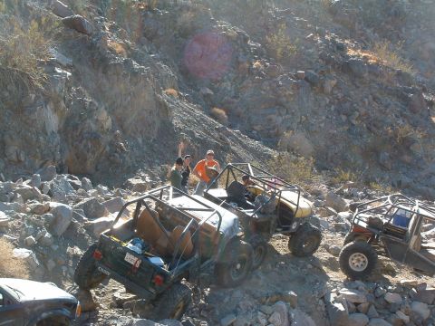 1994 Jeep YJ - Multiple off-road vehicles are shown traversing a challenging, rocky landscape, with spectators observing the action.