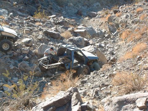 1994 Jeep YJ - Two off-road vehicles tackle a steep, rocky incline in a desert landscape.