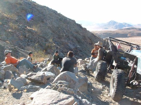 1994 Jeep YJ - A group takes a break from off-roading on a rocky desert trail next to a custom buggy.