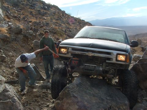 1994 Jeep YJ - A modified Chevrolet S-10 navigates a difficult off-road obstacle with help from bystanders.