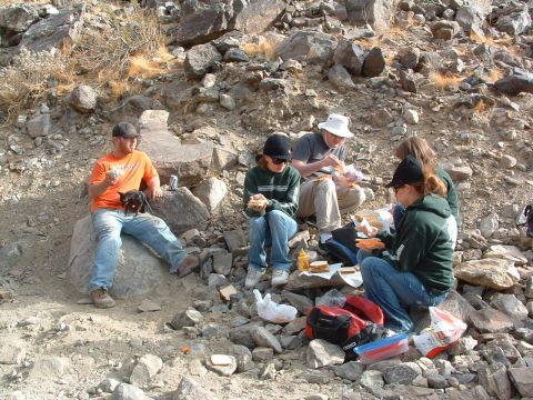 1994 Jeep YJ - A group enjoys a picnic lunch amidst a rocky, arid landscape.