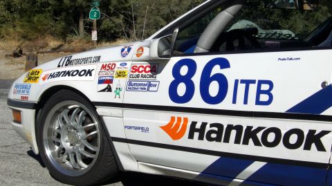 1990 Ford Probe - Side view of a race car, heavily stickered with sponsor logos and racing numbers.