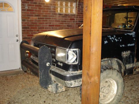 1989 Ford F-250 - A black Ford F-series truck is parked indoors, showing its front 3/4 view with a prominent push bumper.