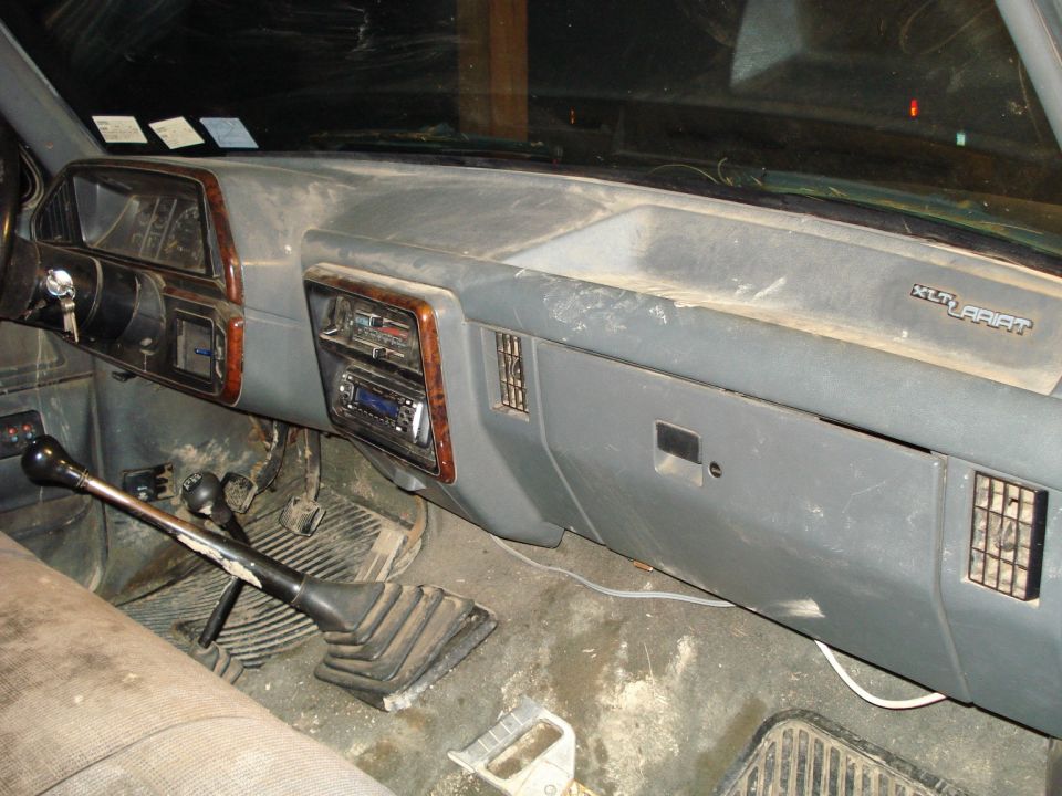 Interior dashboard of a 1989 Ford F-250 with a prominent gear shift and XLT Lariat badging