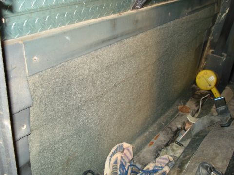 1989 Ford F-250 - Close-up view of the interior of a vehicle, highlighting the carpeted side panel and floor details.