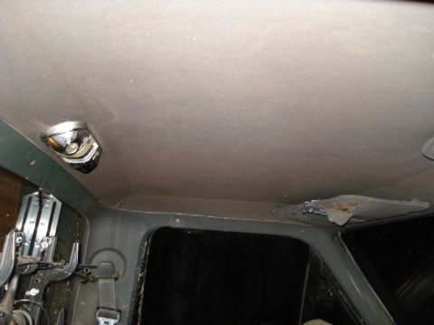 1989 Ford F-250 - The headliner of a vehicle shows a dome light and signs of wear and tear, including rust.