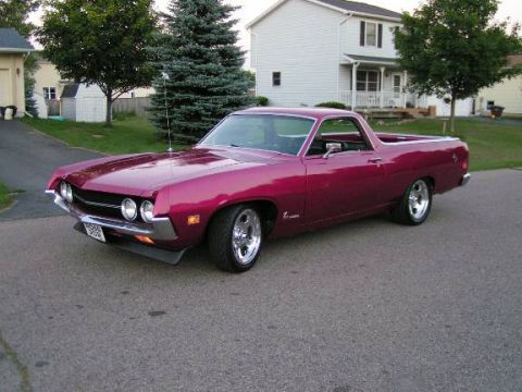 1973 Ford Ranchero - This pink Ford Ranchero, likely from the early 1970s, features custom chrome wheels and a distinctive body style.