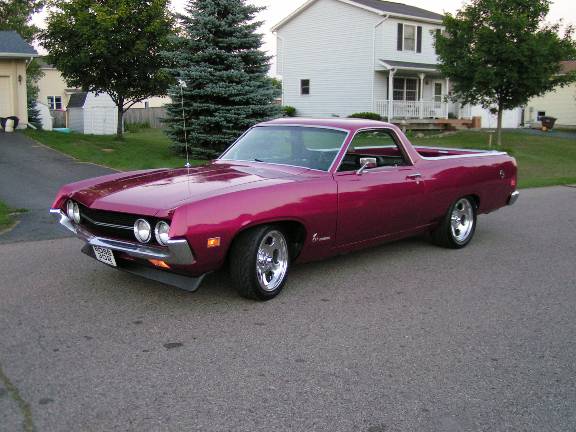 Pink 1970 Ford Ranchero with chrome wheels parked on a suburban street