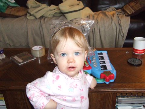 1990 Ford Bronco - A baby with a toy piano on a table, with a couch and blankets in the background.