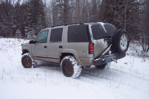 2000 Chevrolet Tahoe - Silver 2000 Chevrolet Tahoe with off-road tires navigates a snowy landscape.