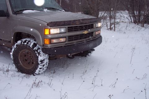 2000 Chevrolet Tahoe - The front grille and bumper of a tan truck are visible in a snowy outdoor setting. The vehicle appears to be from around 1995.
