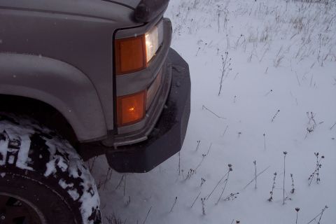 2000 Chevrolet Tahoe - The front corner of a vehicle is shown with snow on the ground and tire.