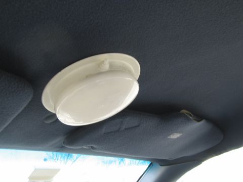 1991 Ford LTD Crown Victoria - The interior of a vehicle shows a dome light and a sun visor against a dark blue headliner.