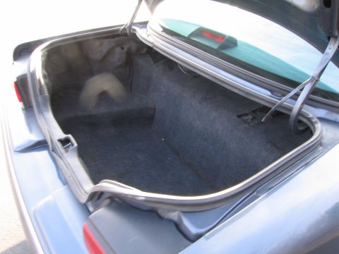 1991 Ford LTD Crown Victoria - The interior of a car's trunk is shown with the lid open.