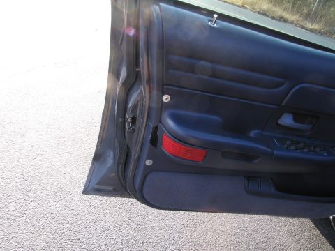 1991 Ford LTD Crown Victoria - Interior view of a dark blue car door panel, showing the door handle and window controls.