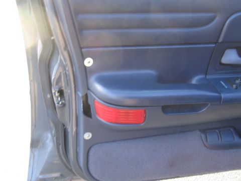 1991 Ford LTD Crown Victoria - Close-up of a car's interior door panel, a red reflector and blue upholstery.