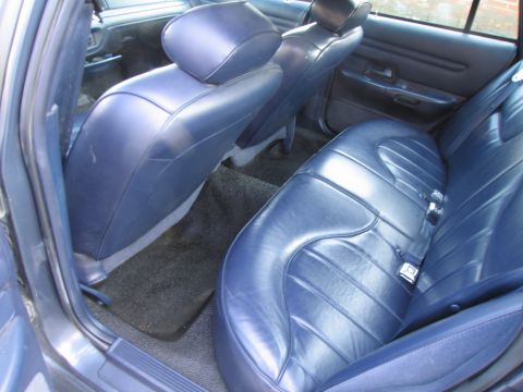 1991 Ford LTD Crown Victoria - The interior of a car features blue leather seats and dark carpeting.