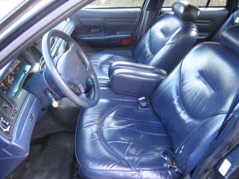 1991 Ford LTD Crown Victoria - The interior of the car features blue leather seats and a dashboard with a visible instrument cluster.