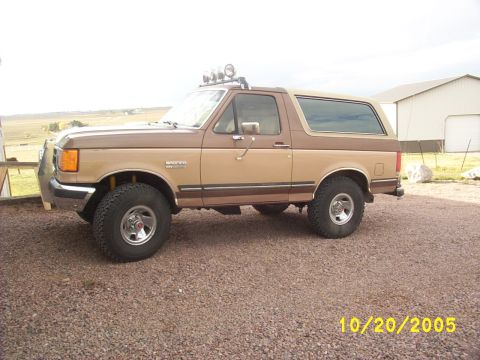 1989 Ford Bronco - This 1989 Ford Bronco is seen from the side, a two-tone brown paint scheme and auxiliary lights on the roof.