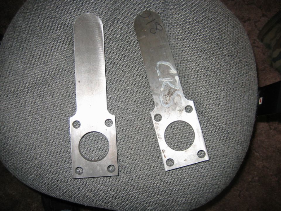 Two metal brackets with circular cutouts and four bolt holes, one marked with 'CR' and '18'