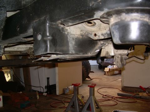 1993 Toyota 4Runner - The underside of a vehicle is shown, supported by jack stands in a garage setting.