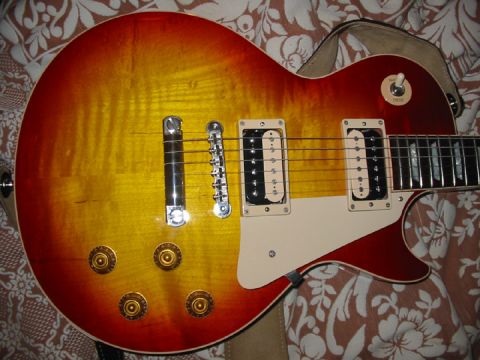 1989 Mazda MX-6 - This sunburst electric guitar features a classic design with dual humbucker pickups and chrome hardware, resting on a patterned fabric.