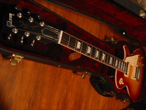 1989 Mazda MX-6 - A Gibson Les Paul electric guitar rests in its case, showing the headstock and fretboard.