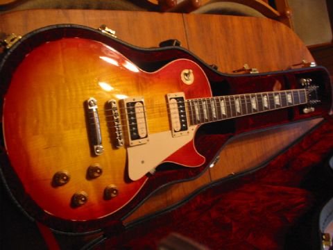1989 Mazda MX-6 - An electric guitar with a sunburst finish rests in its red velvet-lined case.