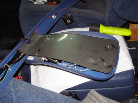 1994 Ford F-150 - A disassembled overhead console part is shown with wiring exposed, alongside a yellow flashlight.